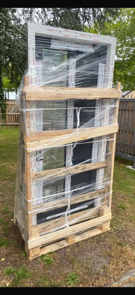 Kozijnen verpakt met beschermfolie en een houten transportframe